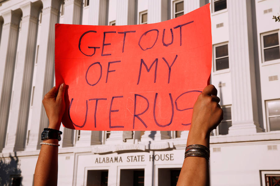 Un manifestante sostiene un cartel en el que se lee 'Sal de mi útero'.