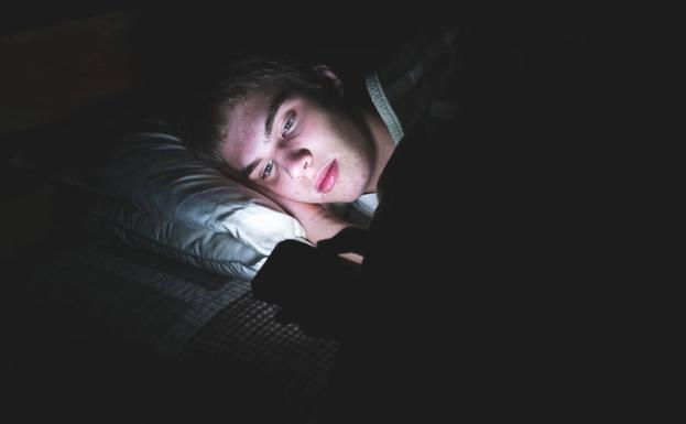 Un adolescente utiliza su móvil a altas horas de la noche.