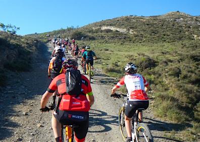 Imagen secundaria 1 - Vista de Cornago desde una pista de la ruta, ciclistas haciendo el recorrido y uno de los senderos