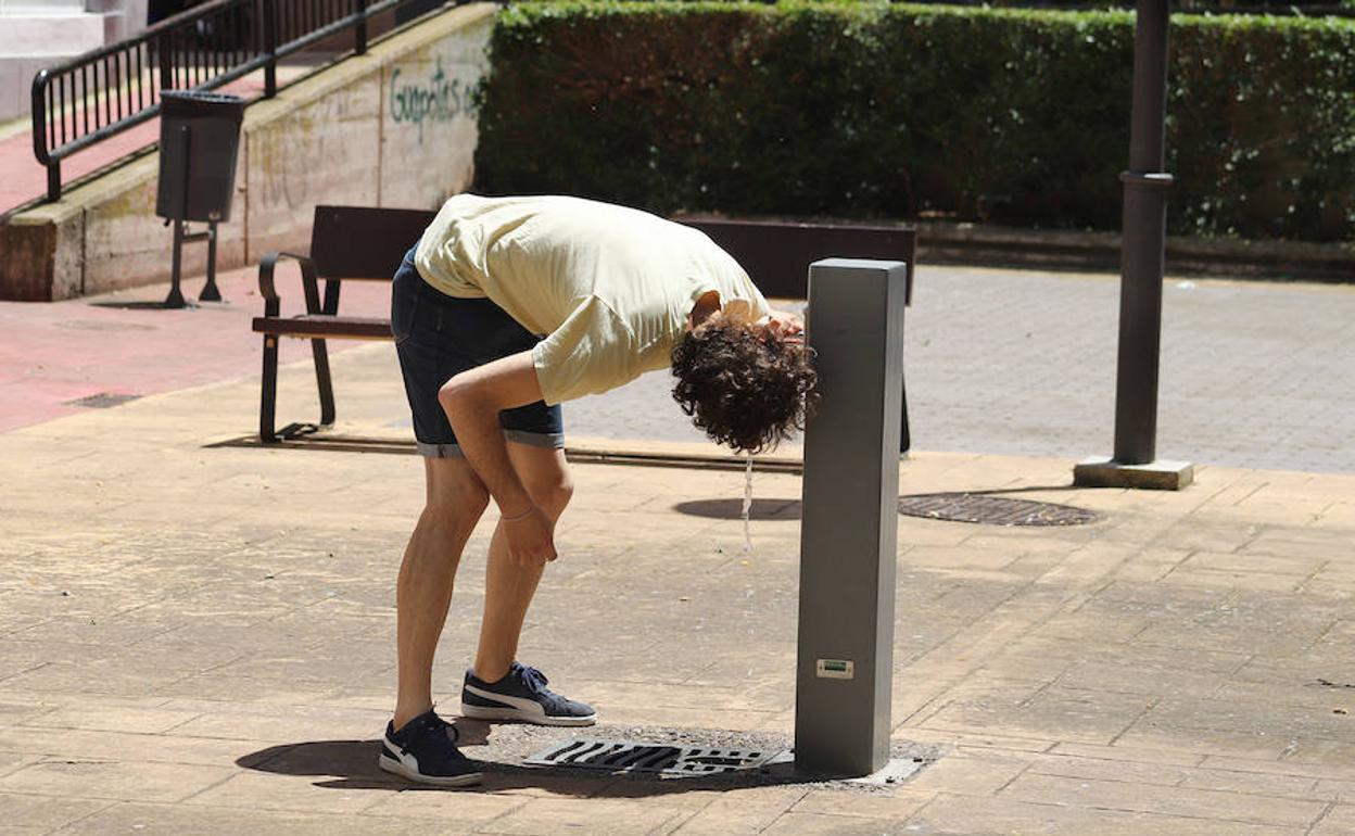 Un joven bebe agua para combatir las altas temperaturas.