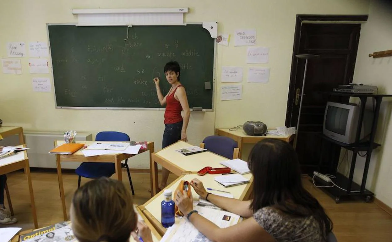 Una profesora enseña idiomas a varios alumnos.