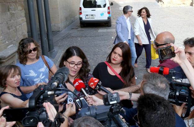 Romero atiende a los medios de comunicación, en presencia de sus asesoras; al fondo, Andreu y Ocón, llegando al Parlamento. :: j. marín