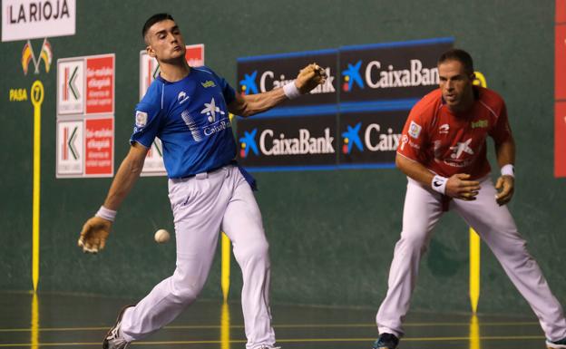 Víctor golpea la pelota con Olaizola mirando atento.