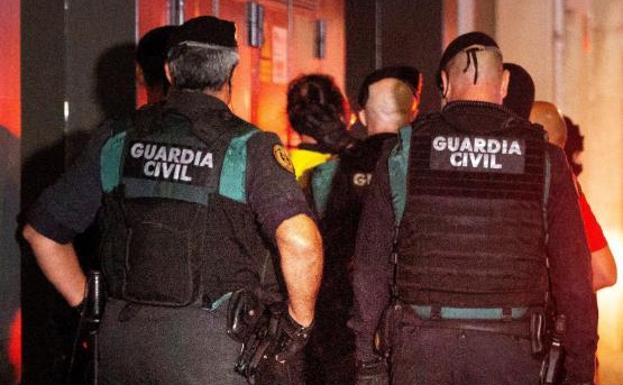 Agentes de la Guardia Civil trasladan a uno de los detenidos por terrorismo.