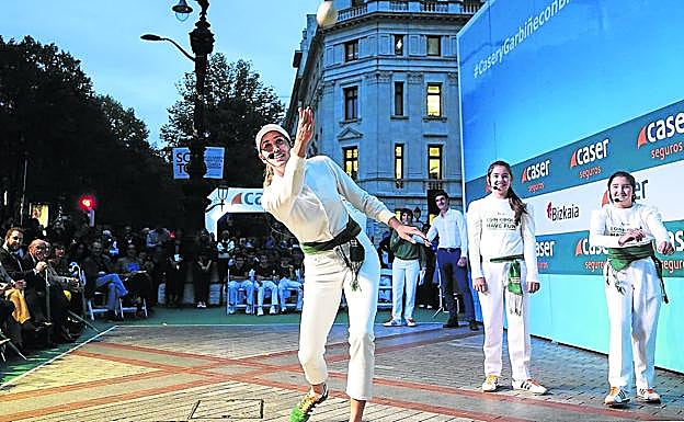 Garbiñe Muguruza pelotea junto a dos niñas en un frontón portátil instalado en Bilbao.
