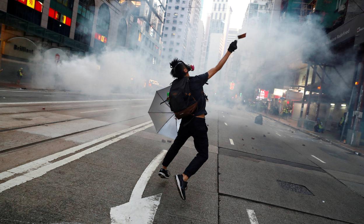 Un manifestante antigubernamental reacciona cuando la policía dispara gases lacrimógenos.