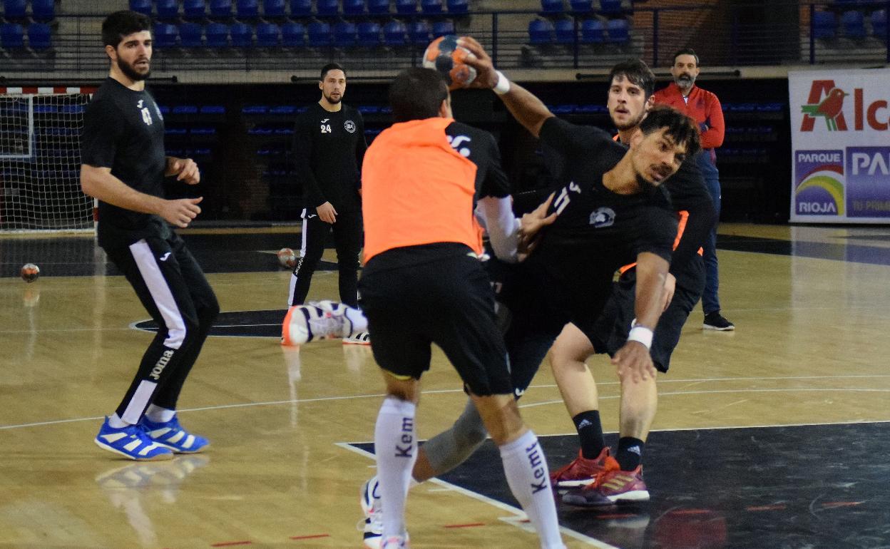 Edu Cadarso y Tomás Moreira intentan detener a Junior Scott en un entrenamiento