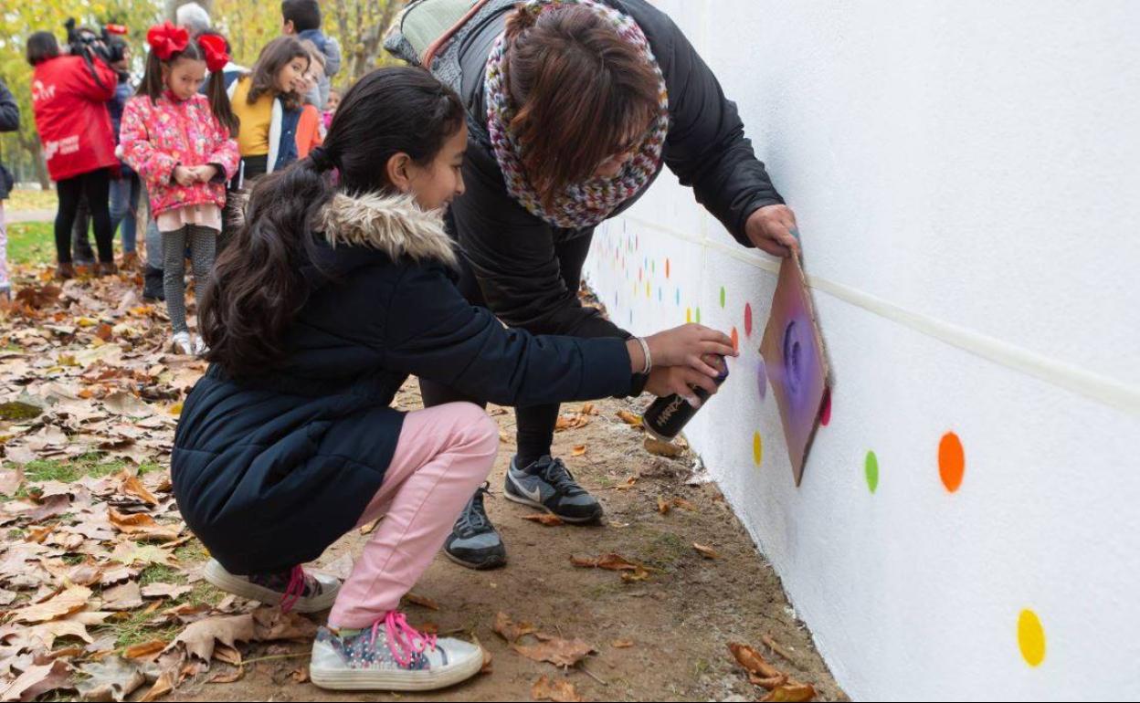 Profesores y niños del colegio logroñés Navarrete el Mudo, frente al muro sobre el que se ha empezado a trabajar.