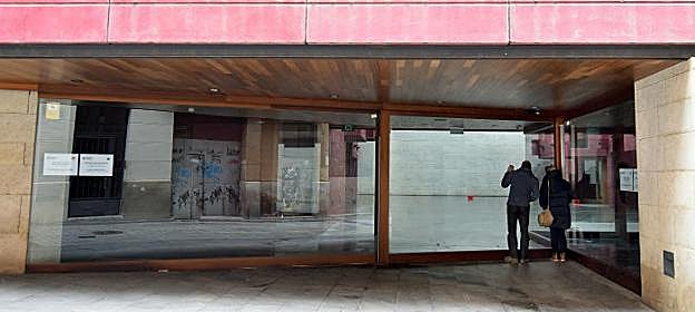 Acceso al gran vestíbulo del Centro de la Cultura del Rioja, desde el que unas personas miran el interior