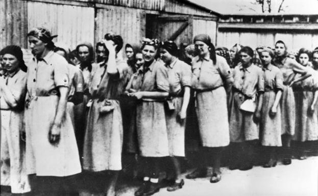 Mujeres aguardan su destino durante el reparto de trabajos forzados.