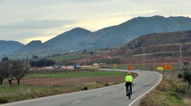 Un ciclista que circula por la LR-261 se acerca a la zona de obras, en Ventas Blancas, donde se instalará la planta de yeso de Fassa Bortolo. 