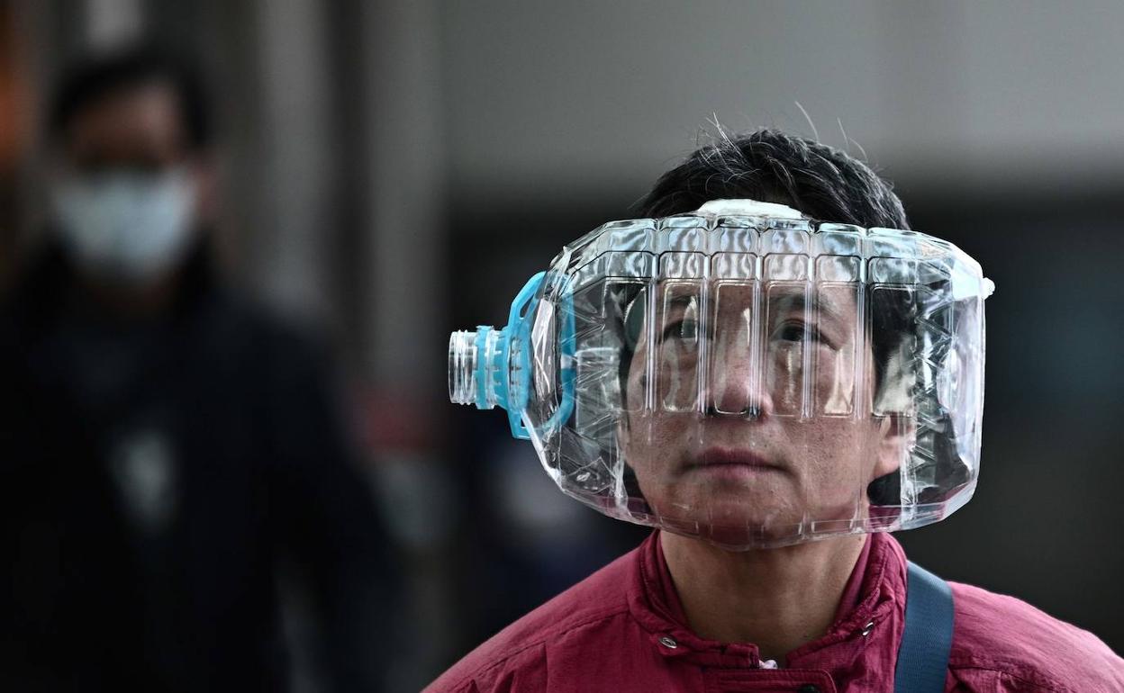 Los ciudadanos chinos, como este hombre en Hong Kong, utilizan cualquier método ante la carencia de mascarillas para protegerse del coronavirus.