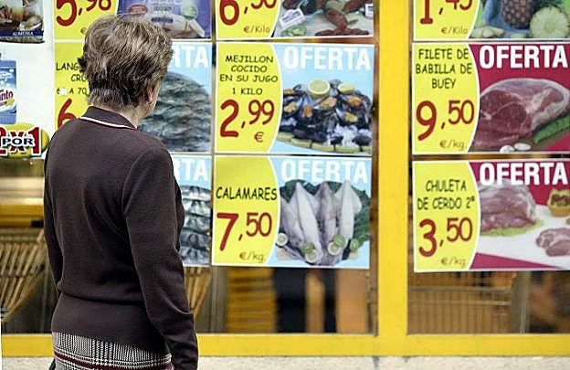 Un consumidor, ante las ofertas de productos alimentarios en un supermercado.