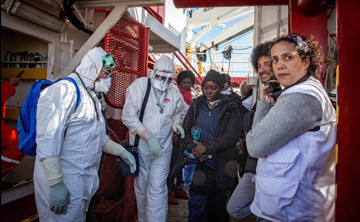 Inmigrantes son dirigidos a la zona de cuarentena tras desembarcar.