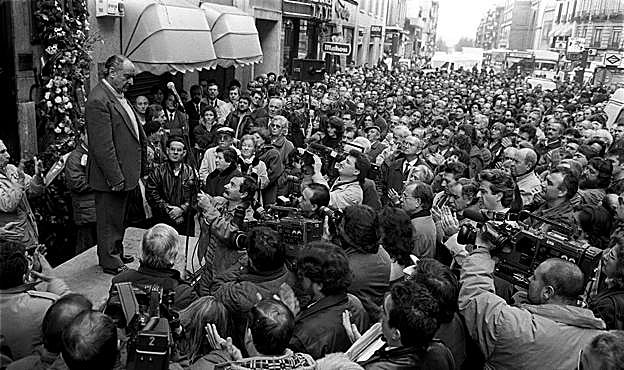 Miguel Sarabia, subido a una plataforma, recibe los aplausos de cientos de madrileños ante el número 55 de la calle de Atocha de Madrid con motivo del 20 aniversario del asesinato de los abogados laboralistas. 