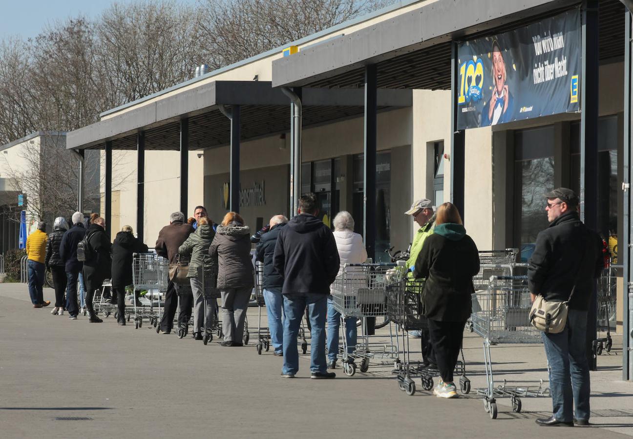 Una larga fila de personas esperan en la cola para acceder a un supermercado en Schulzendorf, cerca de Berlín.