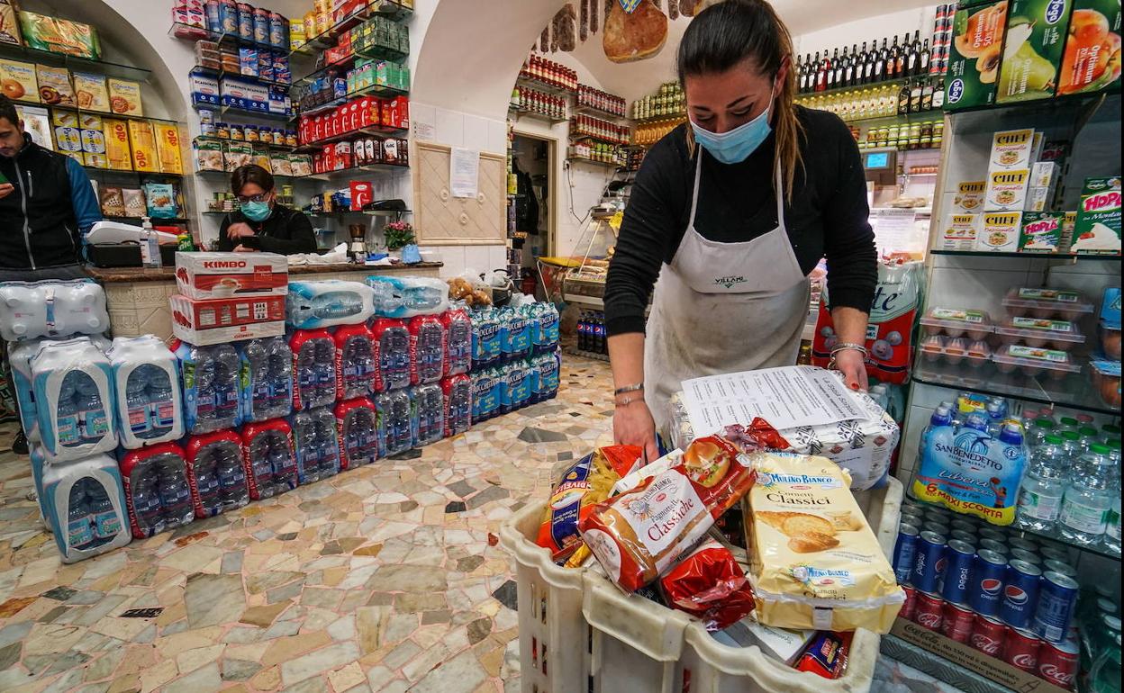 Una empleada coloca la compra de un cliente en una caja.