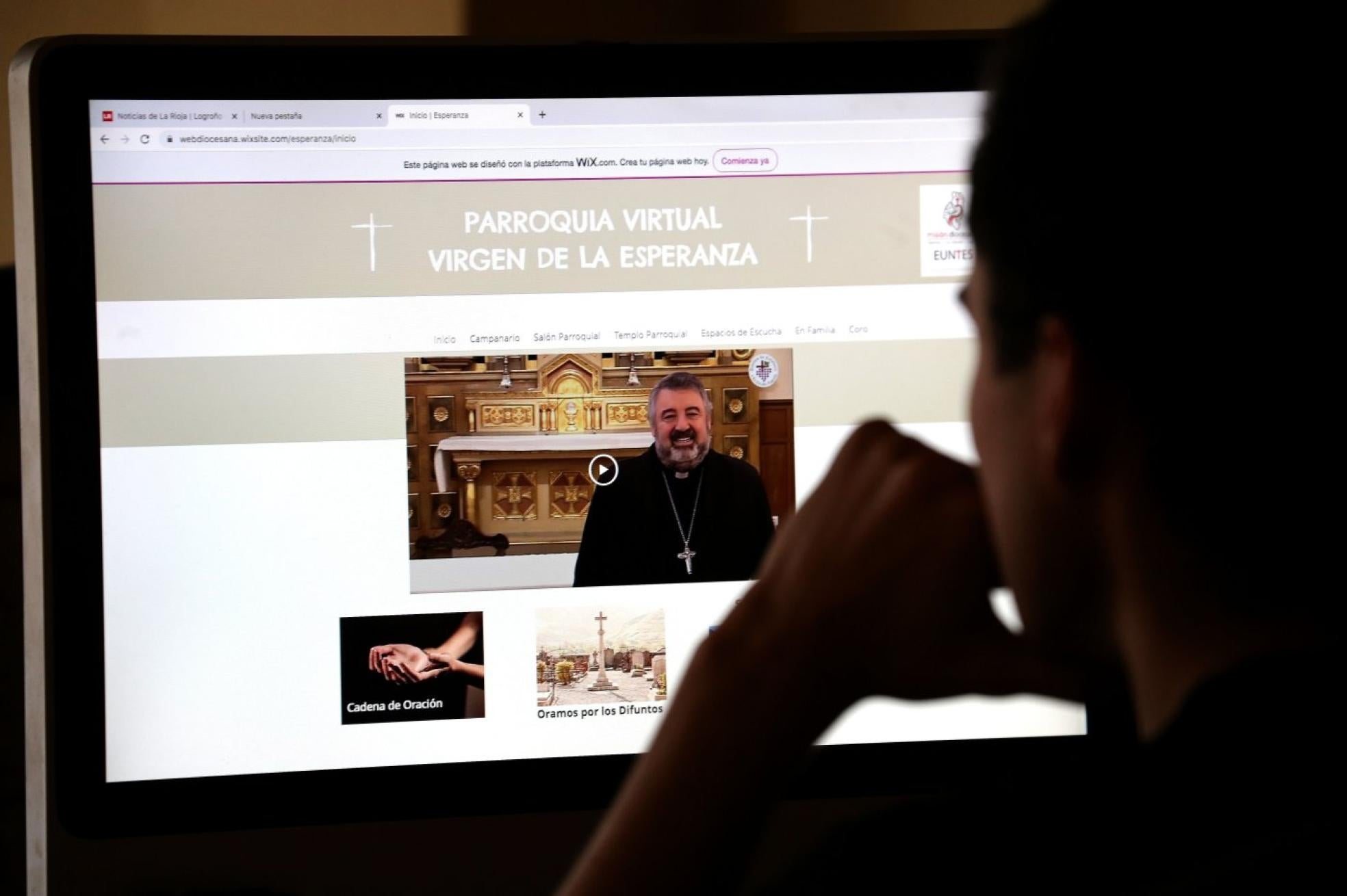 Un feligrés mira la web de la parroquia virtual creada por la diócesis.