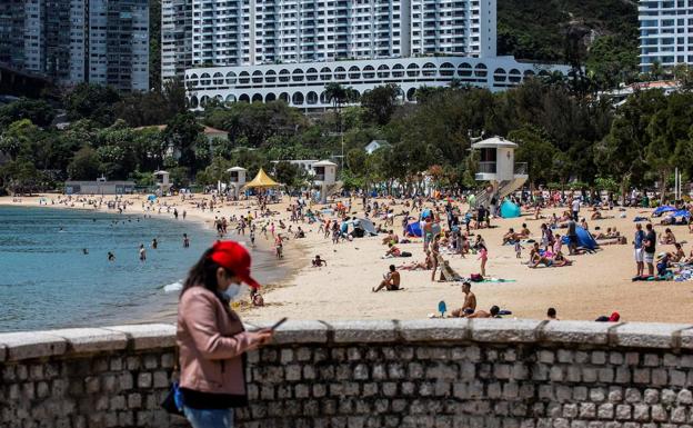 Una playa en Hong Kong, donde los bañistas vuelven a la arena. aunque algunos ciudadanos no se quitan la mascarilla.