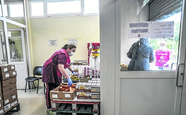 Imagen principal - Arriba, María Ángeles Lacarra prepara alimentos mientras una mujer recoge fuera la caja que le han preparado. A la derecha, Pilar, con comida para bebés. A la izquierda, María Ángeles ayuda a Yorleny a empujar el carro. 