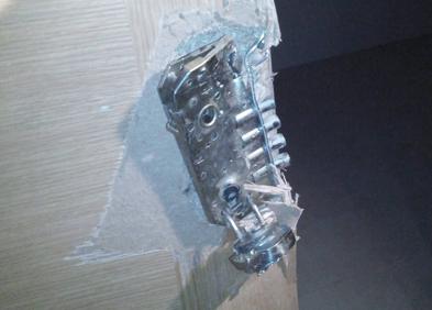 Imagen secundaria 1 - La Guardia Civil, frente a la vivienda. Abajo, detalle de los daños en la puerta.