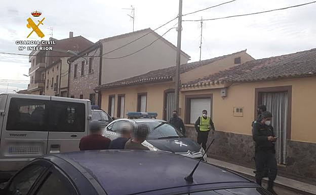 Imagen principal - La Guardia Civil, frente a la vivienda. Abajo, detalle de los daños en la puerta.
