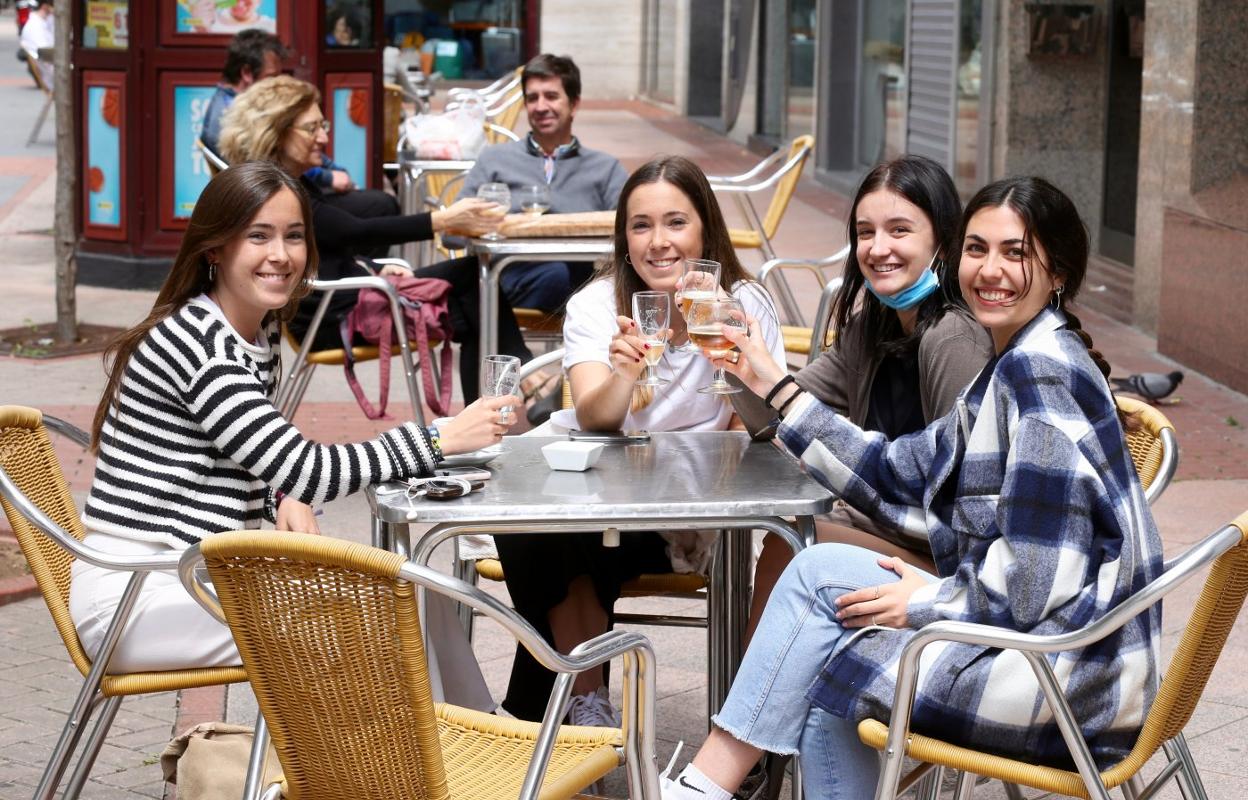 Cuatro sonrientes jóvenes brindan en una terraza del paseo de las Cien Tiendas camino de la 'nueva normalidad'. 