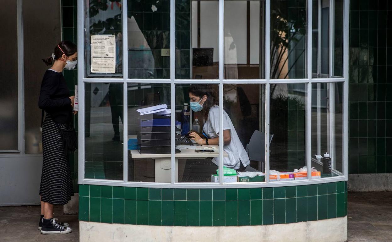 Una profesional sanitaria del CAP (centros de atención primaria), atiende a una visita.