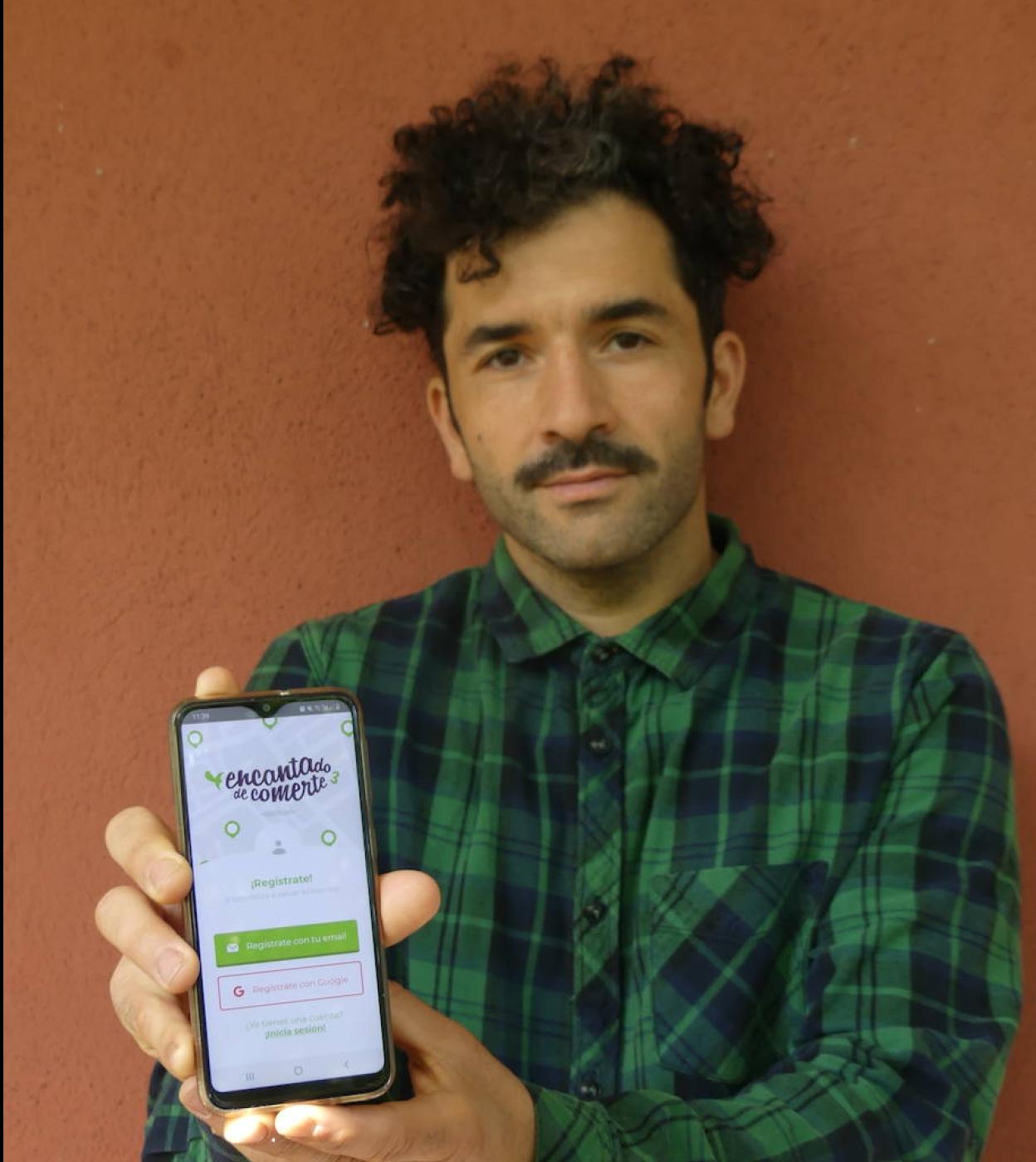 Enrique de Miguel muestra la aplicación en su móvil. 