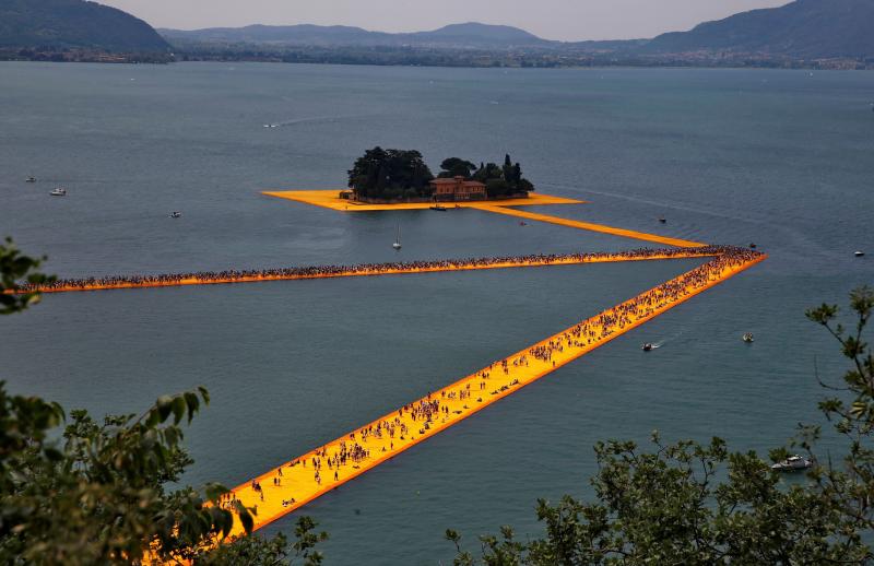 En la obra 'The Floating Piers', Christo y Jeanne-Claude utilizaron 70,000 metros cuadrados de tela amarilla, transportada por un sistema de muelle flotante modular de 226,000 cubos de polietileno de alta densidad. Fue instalada en 2016 en el lago Iseo, cerca Brescia, Italia.