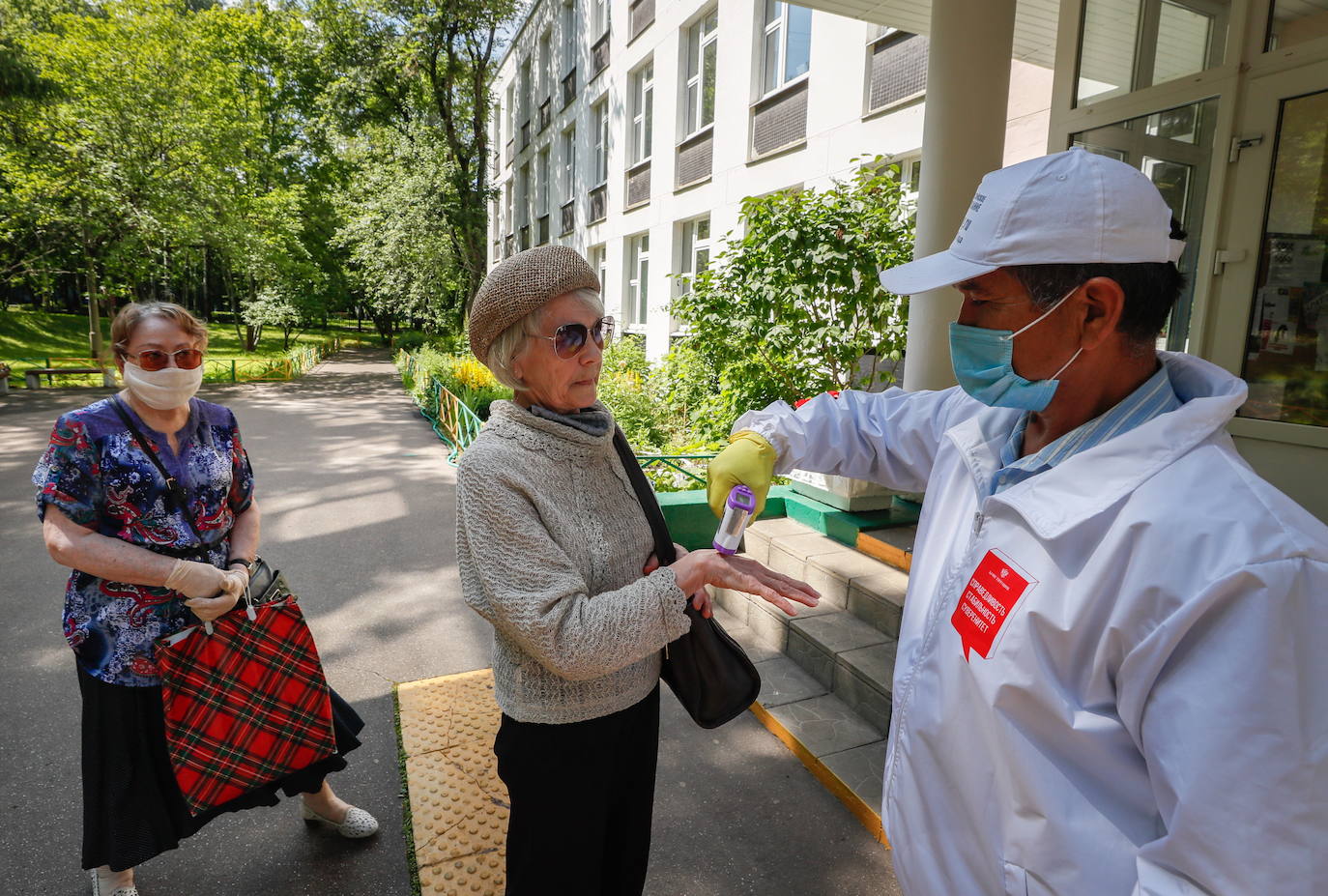 Un sanitario toma la temperatura a dos mujeres en Moscú. 