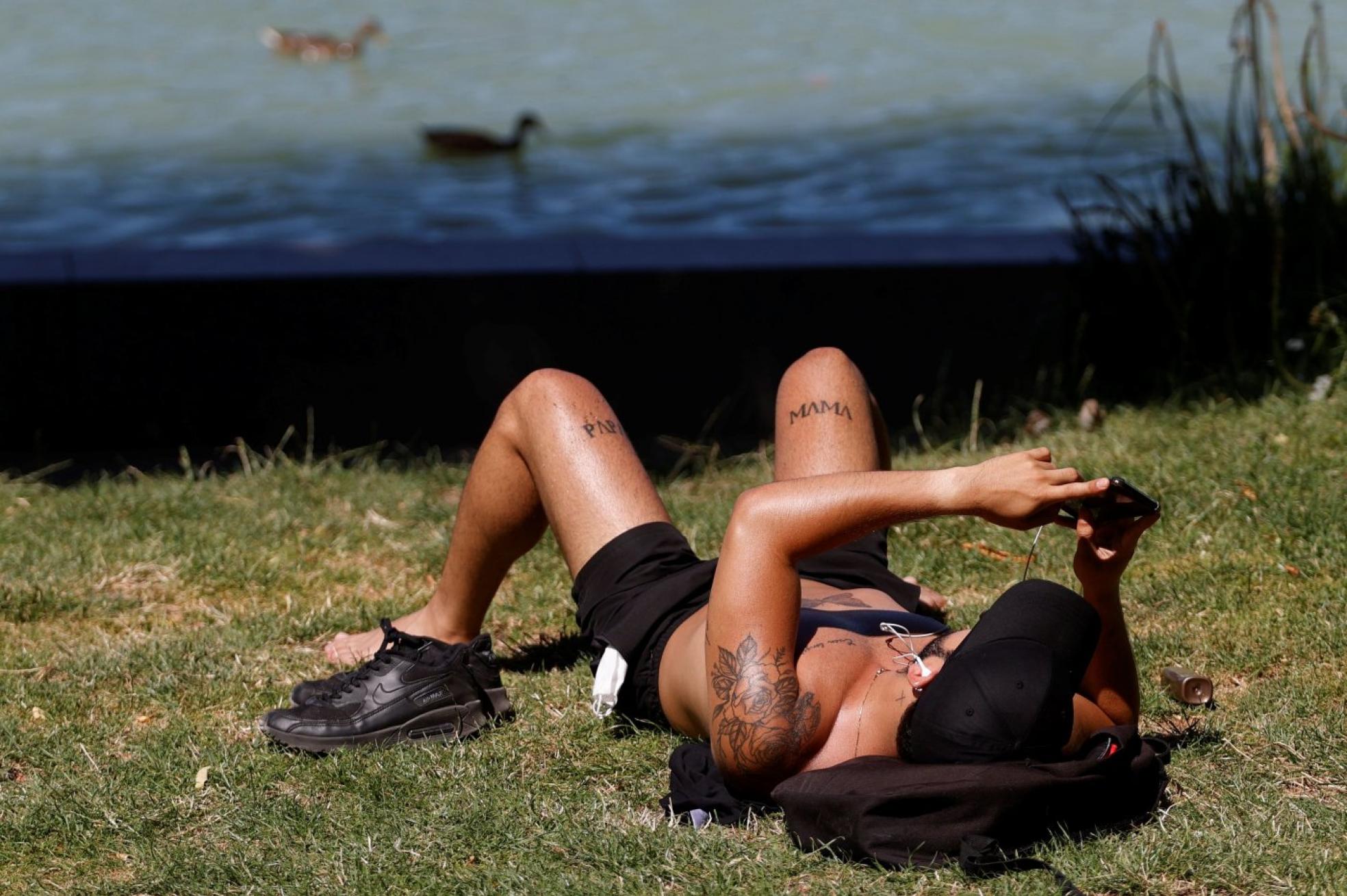 Tomando el sol en un parque tras el confinamiento. 