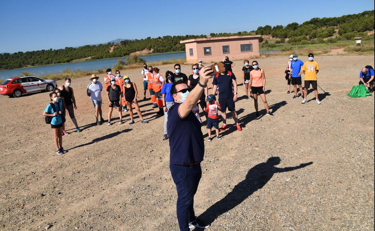 Paco Rivero realiza un selfie con parte de los asistentes y el pantano del Perdiguero al fondo.