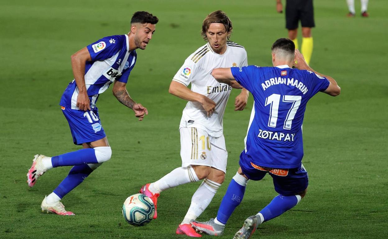 Luka Modric, perseguido por dos jugadores del Alavés. 