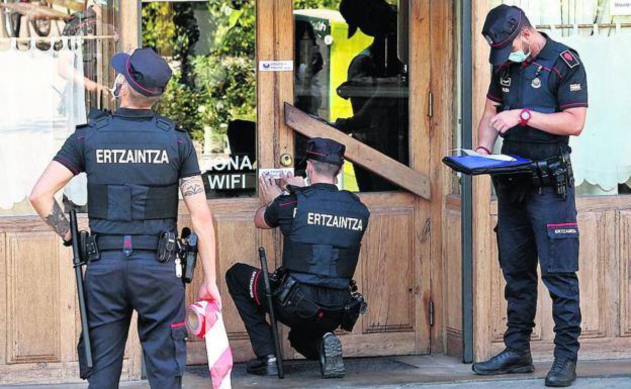 Ertzainas precintan un restaurante en una céntrica plaza de Vitoria. 