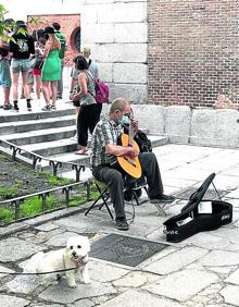 Imagen secundaria 2 - La Plaza Mayo (arriba), la Puerta del Sol (centro) o el Museo de Prado, donde toca un músico callejero (abajo), son los centros turísticos de obligada visita en Madrid.