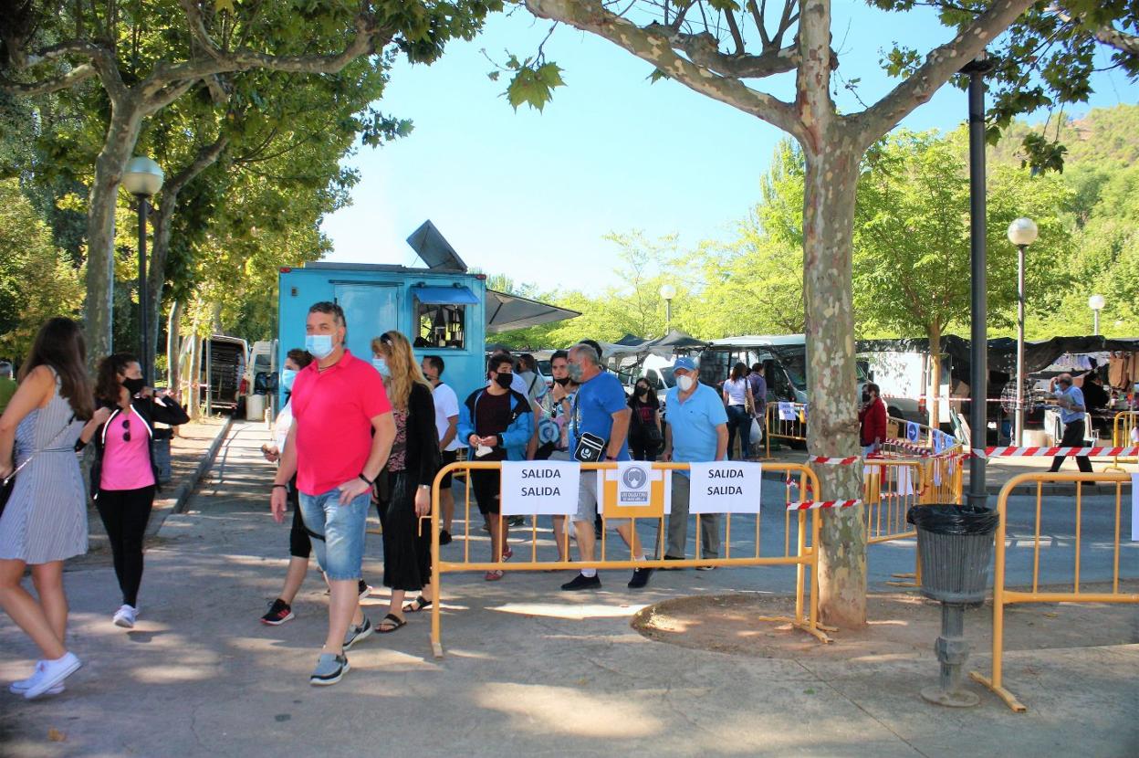 Asistentes al mercadillo del pasado jueves dejan el mismo por la zona habilitada para salir, tras haber recorrido los puestos. 