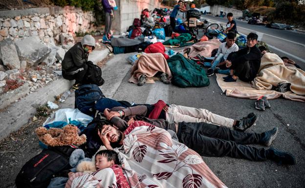 Varias familias de refugiados duermen en una carretera cercana al campamento de refugiados destruido en Lesbos.