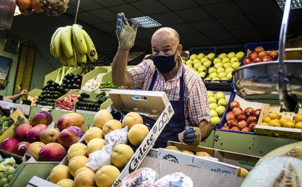 Imagen principal - Javier Álvarez, en su frutería. Un puesto del mercado de Vallecas. Víctor Mendoza.