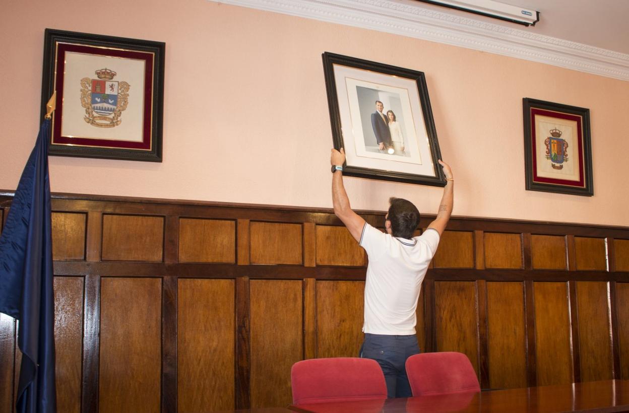 Imagen de archivo del concejal del PP Raúl Riaño colocando la foto de los Reyes en el salón de plenos. 