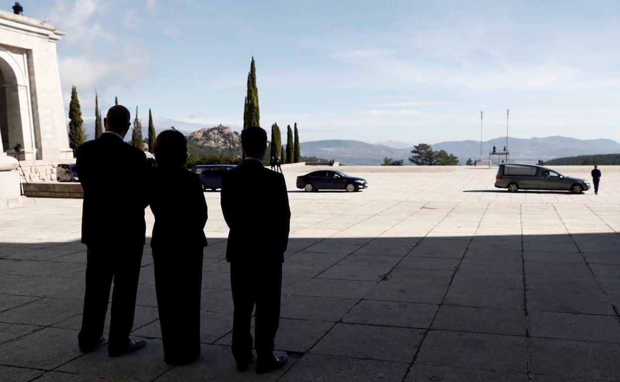 La entonces ministra de Justicia, Dolores Delgado, (centro) junto a la delegación del Gobierno observa como se aleja del Valle de los Caídos el furgón con los restos del exjefe del Estado Francisco Franco.