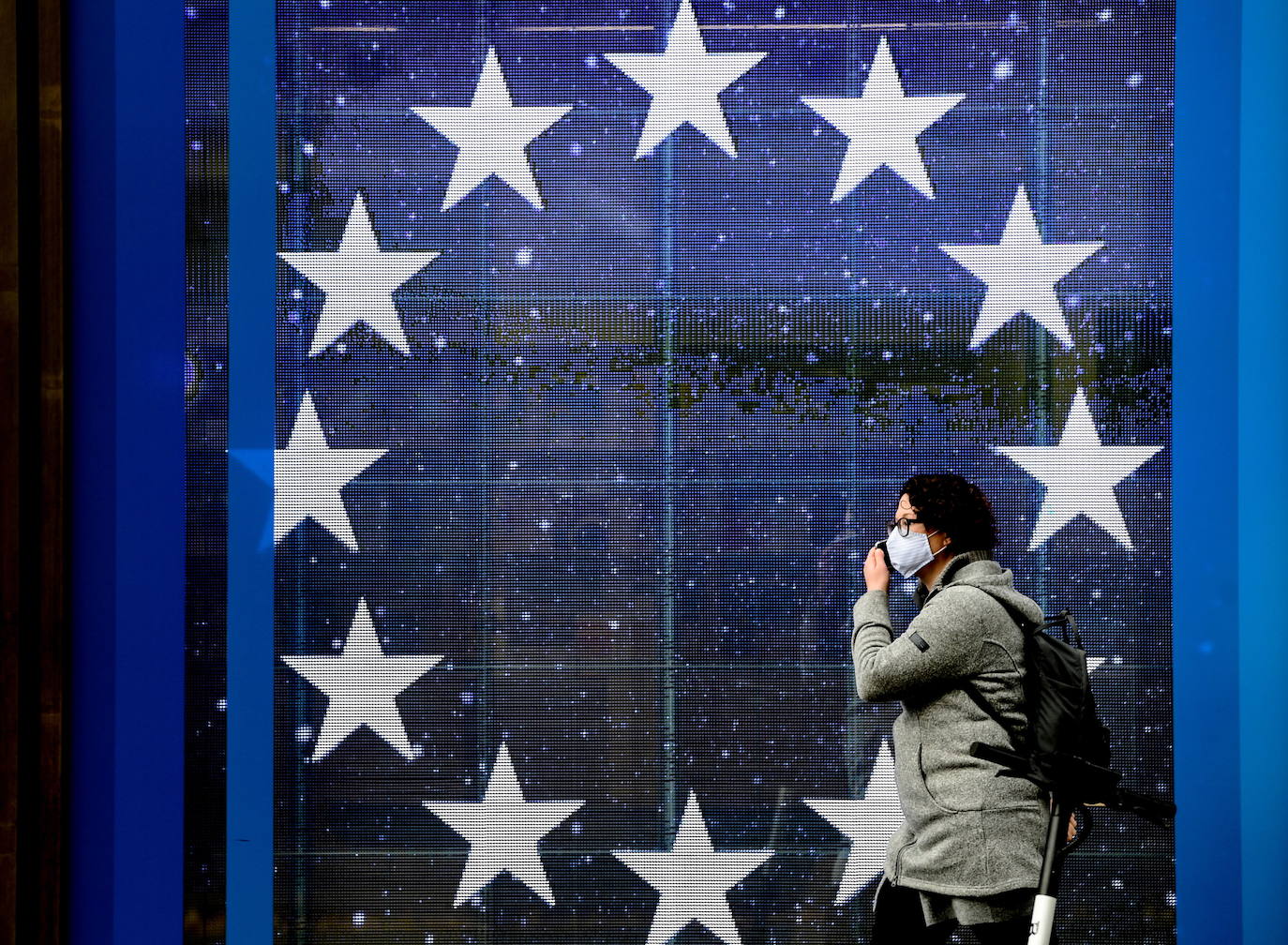 Una mujer con mascarilla camina al pie de la sede de la Comisión Europea en Berlín 