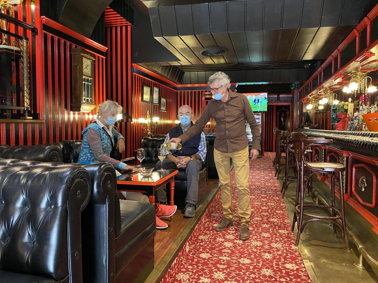 Rafa Villanueva atiende en la mesa a un cliente y su mujer, que también le ayuda a llevar la cafetería.