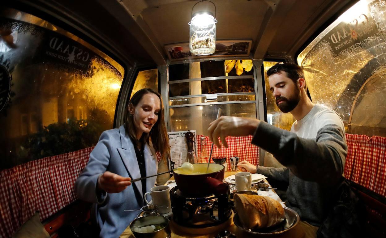 Una pareja degusta una fondue, el plato nacional suizo. 