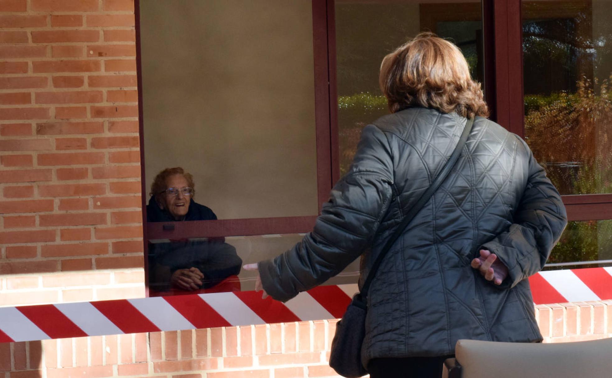 Pilar, usuaria de la residencia Santa Justa, sonríe al recibir la visita de su hija Lola.