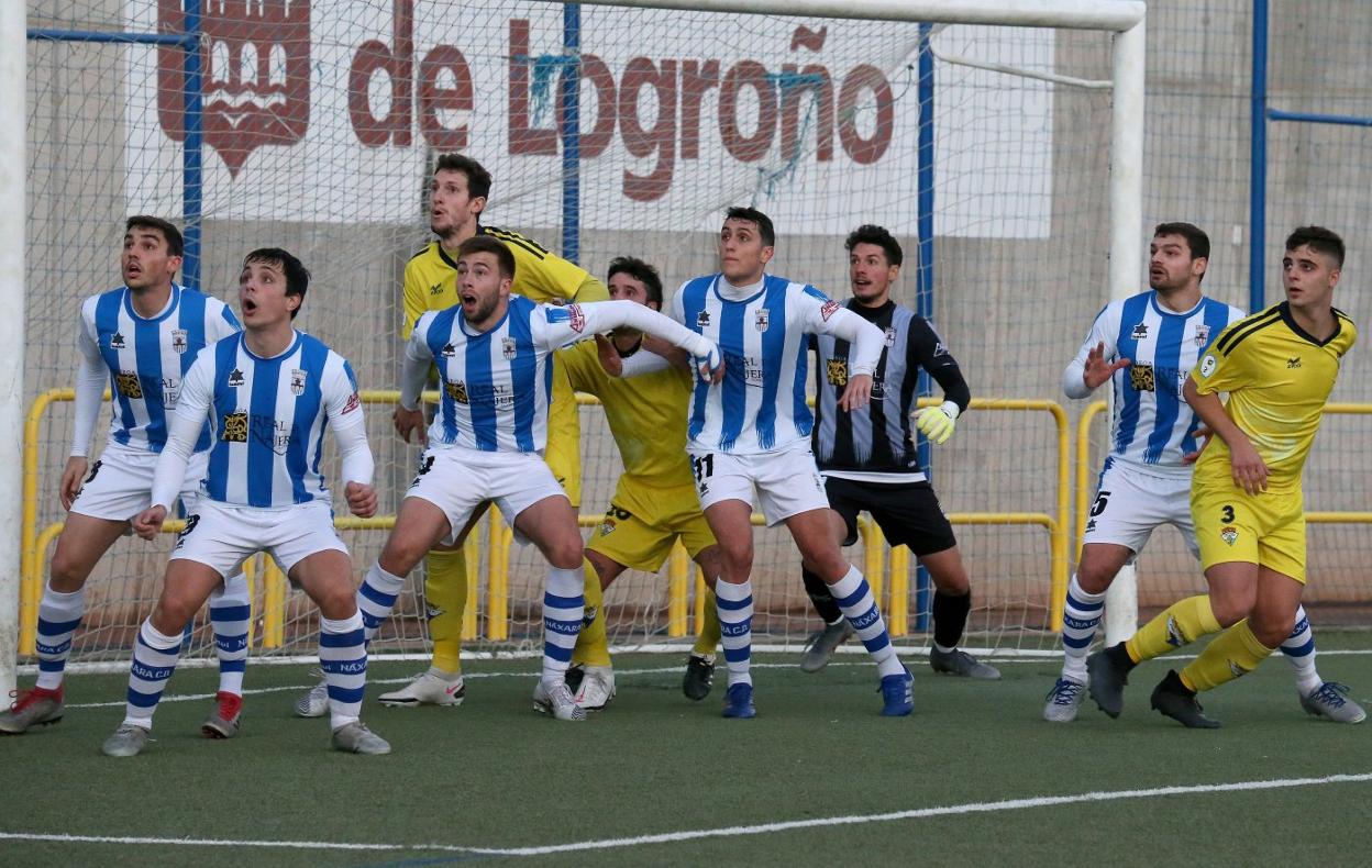 Varios jugadores de ambos equipos, dentro del área del Náxara, esperando el saque de esquina. 