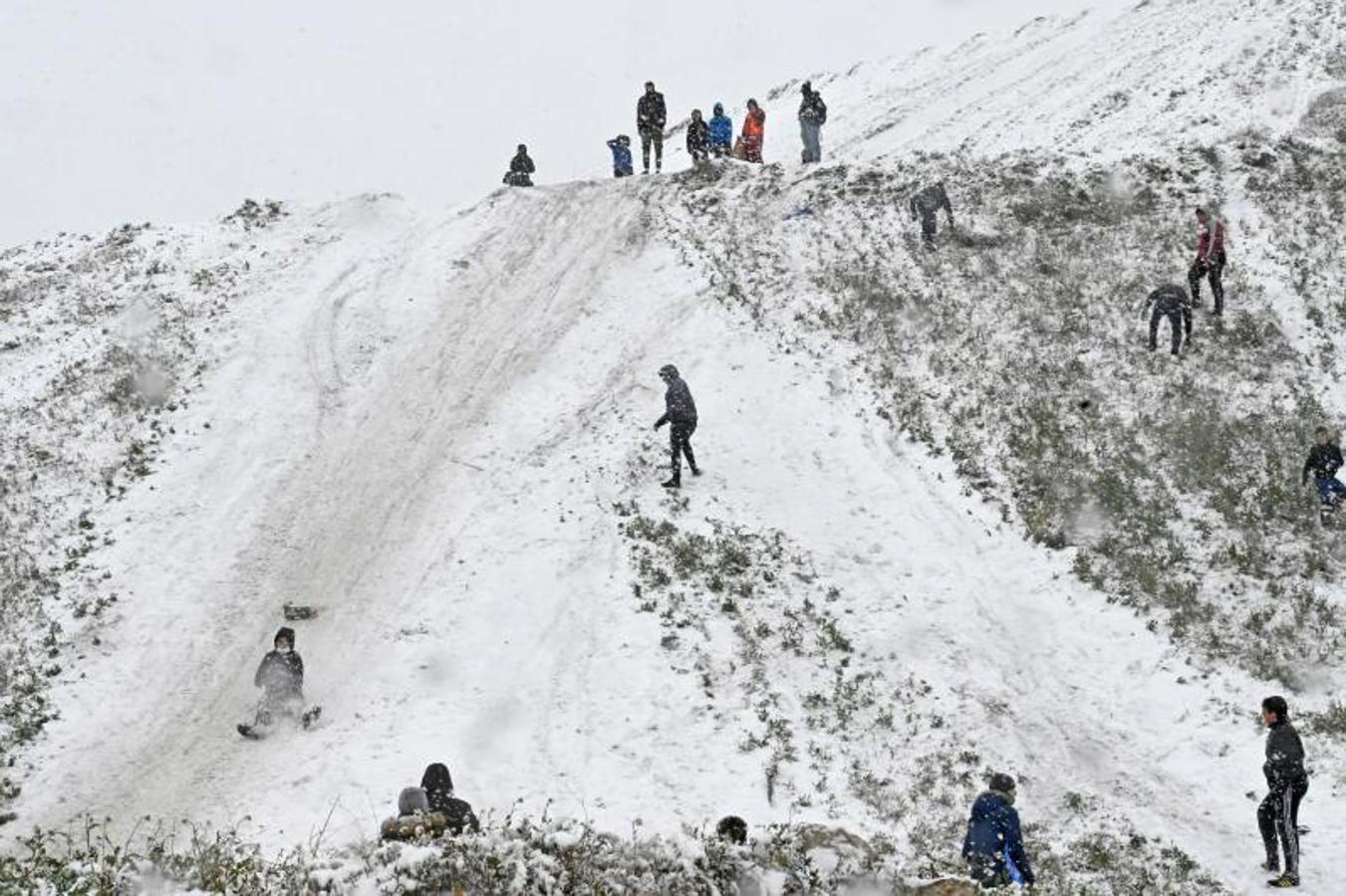 Niños de la Cañada se tiran por un terraplén cubierto de nieve este viernes en Madrid,