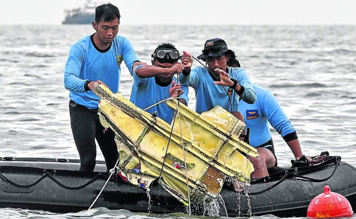 Buzos de la Armada indonesia recuperan restos del avión de la aerolínea Sriwijaya siniestrado el sábado.