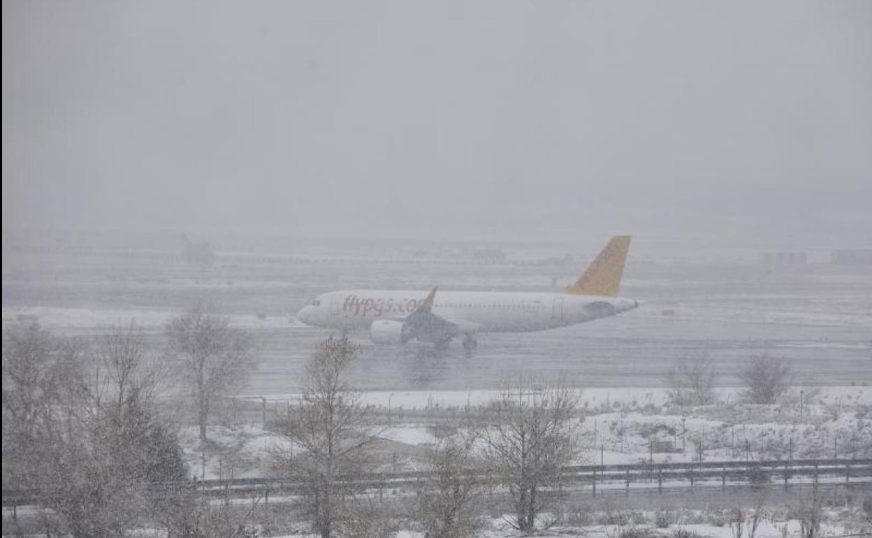 Una avión en el aeropuerto de Barajas, completamente lleno de nieve.