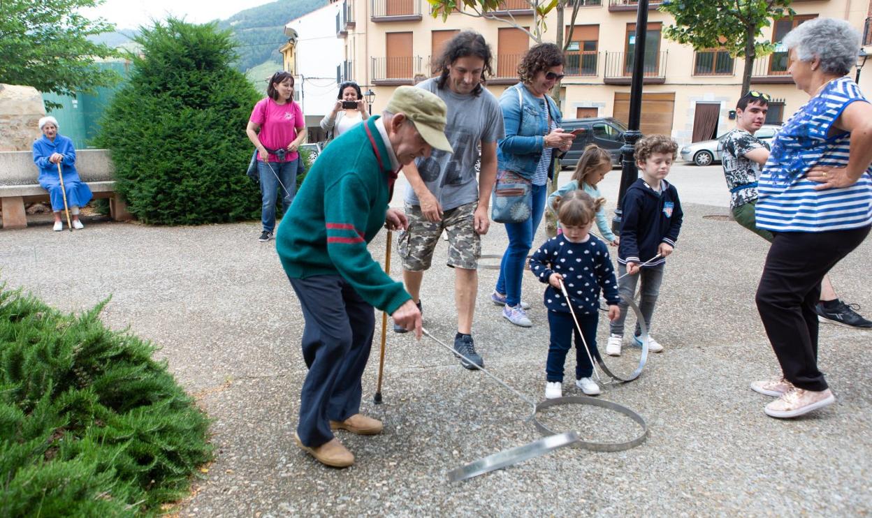 Un abuelo enseña a jugar a los niños. 